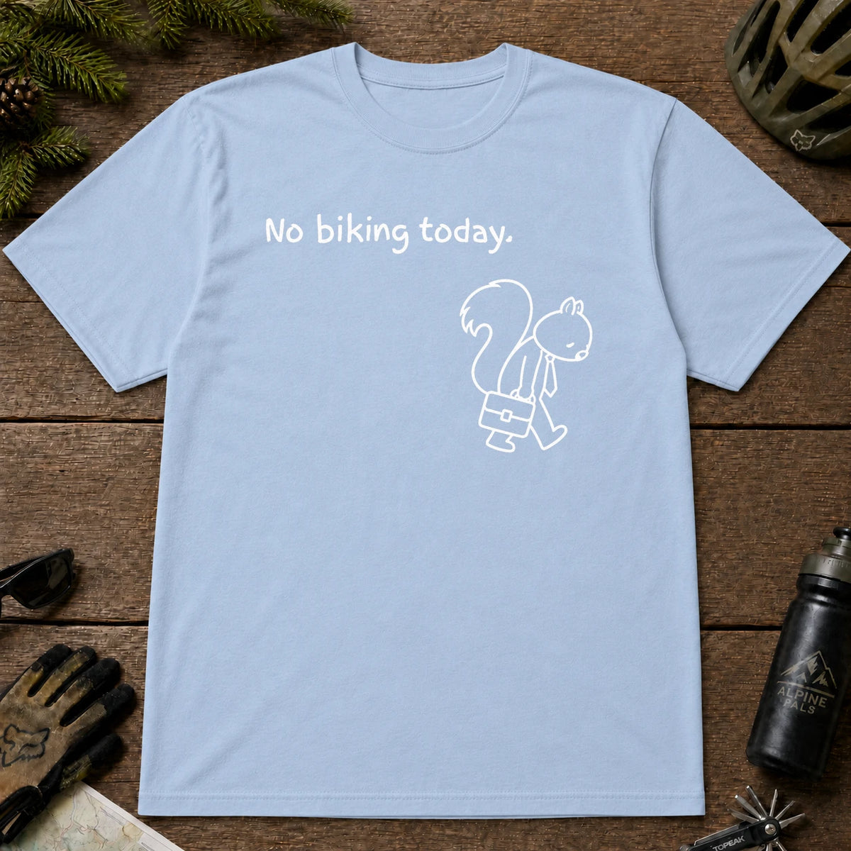 Light Blue tee featuring a sad squirrel dressed for work and carrying a briefcase beneath the phrase “No biking today.”