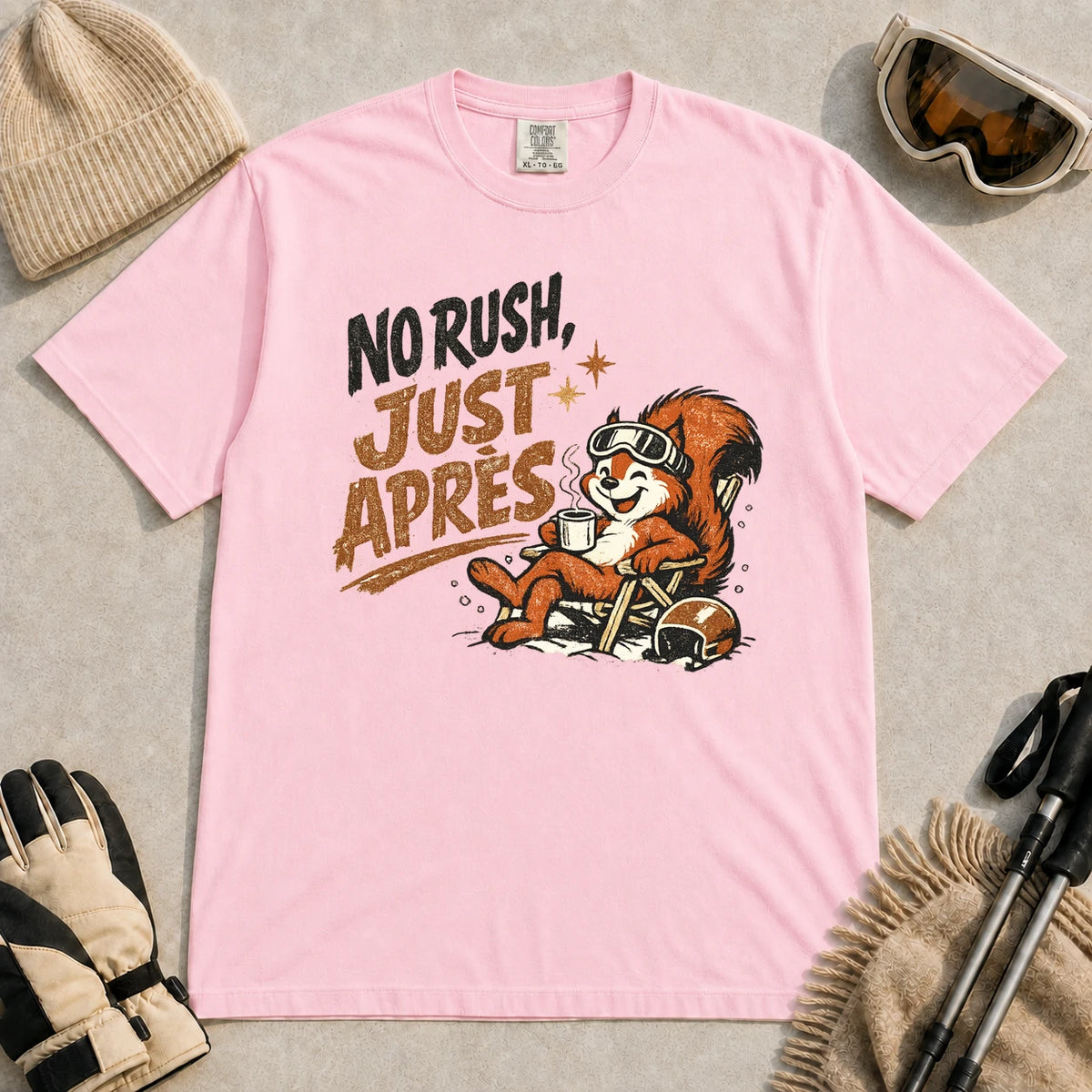 Blossom tee featuring a cheerful squirrel in ski goggles relaxing in a chair with a hot drink and helmet, with the phrase “No Rush, Just Après.”