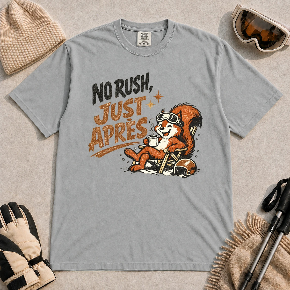 Granite tee featuring a cheerful squirrel in ski goggles relaxing in a chair with a hot drink and helmet, with the phrase “No Rush, Just Après.”