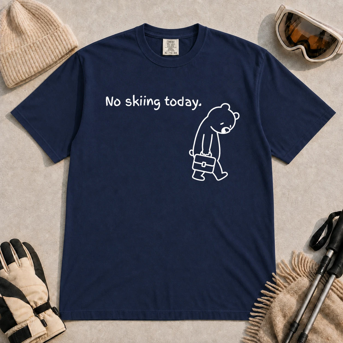 True Navy tee featuring a sad bear dressed for work and carrying a briefcase beneath the phrase “No skiing today.”