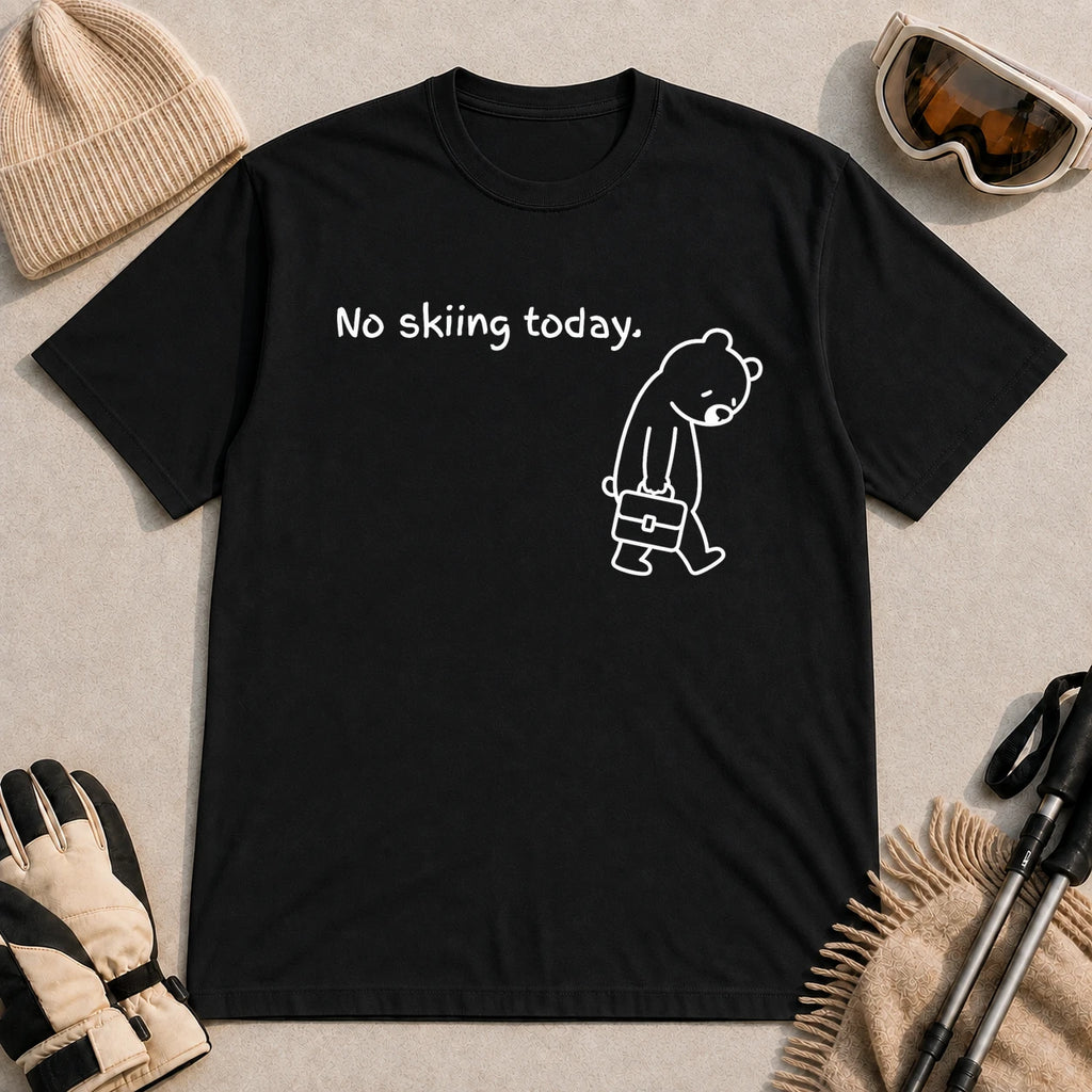 Black tee featuring a sad bear dressed for work and carrying a briefcase beneath the phrase “No skiing today.”