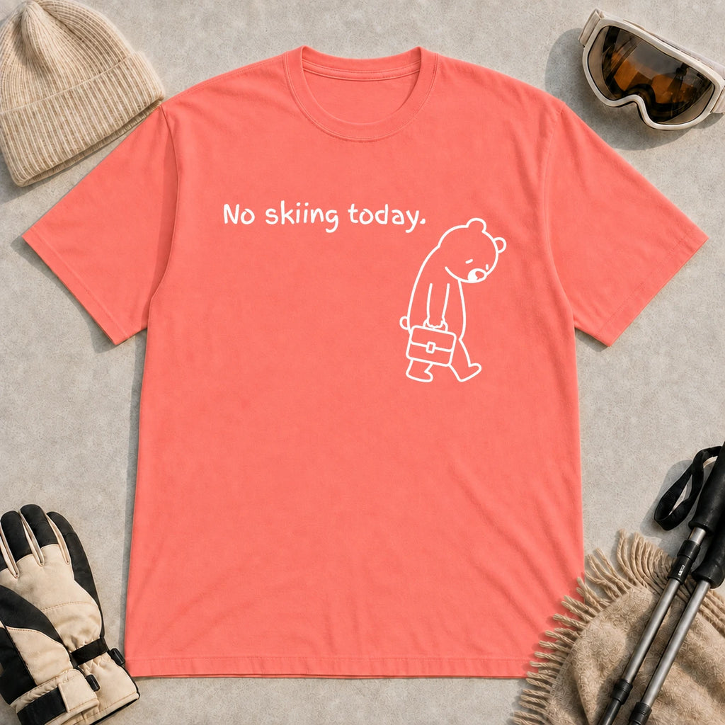 Coral Silk tee featuring a sad bear dressed for work and carrying a briefcase beneath the phrase “No skiing today.”
