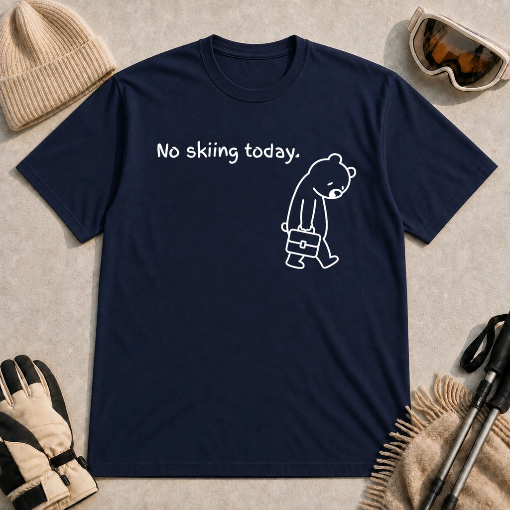 Navy tee featuring a sad bear dressed for work and carrying a briefcase beneath the phrase “No skiing today.”