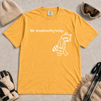 Mustard tee featuring a sad raccoon dressed for work and carrying a briefcase beneath the phrase “No snowboarding today.”