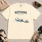 Ivory tee featuring a relaxed otter soaking in a hot spring beside ski goggles and a beanie, with the phrase “Nothing Pending.”