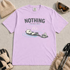 Orchid tee featuring a relaxed otter soaking in a hot spring beside ski goggles and a beanie, with the phrase “Nothing Pending.”