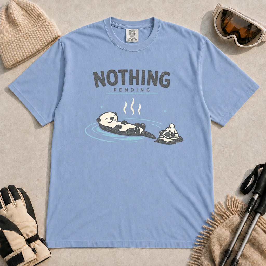 Washed Denim tee featuring a relaxed otter soaking in a hot spring beside ski goggles and a beanie, with the phrase “Nothing Pending.”