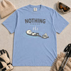 Washed Denim tee featuring a relaxed otter soaking in a hot spring beside ski goggles and a beanie, with the phrase “Nothing Pending.”