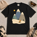 Black tee featuring a cute pika skiing beneath stylized snow-capped mountain peaks, evergreen trees, and a golden sun.