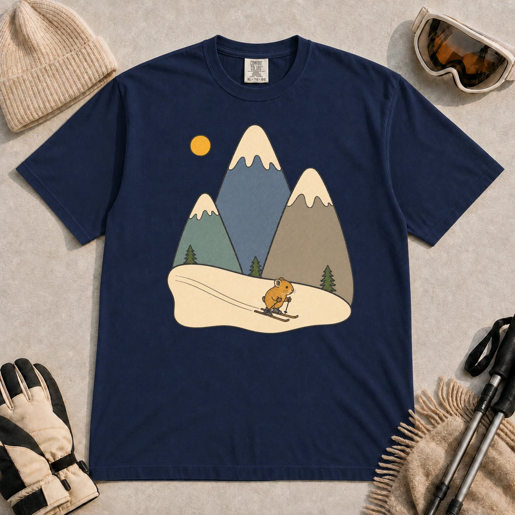 True Navy tee featuring a cute pika skiing beneath stylized snow-capped mountain peaks, evergreen trees, and a golden sun.
