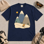 True Navy tee featuring a cute pika skiing beneath stylized snow-capped mountain peaks, evergreen trees, and a golden sun.