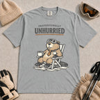 Granite tee featuring a relaxed beaver in ski goggles sitting in a chair with a hot drink, with the phrase “Professionally Unhurried.”