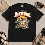 Black tee featuring a relaxed marmot lounging in a chair with a hot drink beside ski goggles, backed by mountains and a retro sunset with the phrase “Resting Altitude.”
