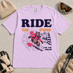 Orchid tee featuring a bear snowboarding through powder in a retro mountain scene with the phrases “Ride the Pow” and “Live the Dream.”
