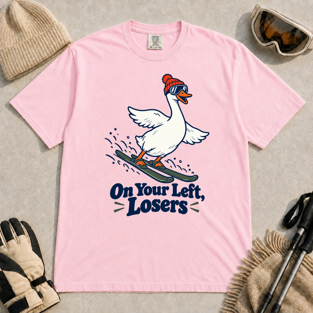 Blossom tee featuring a playful goose skiing in goggles and a beanie above the phrase “On Your Left, Losers.”
