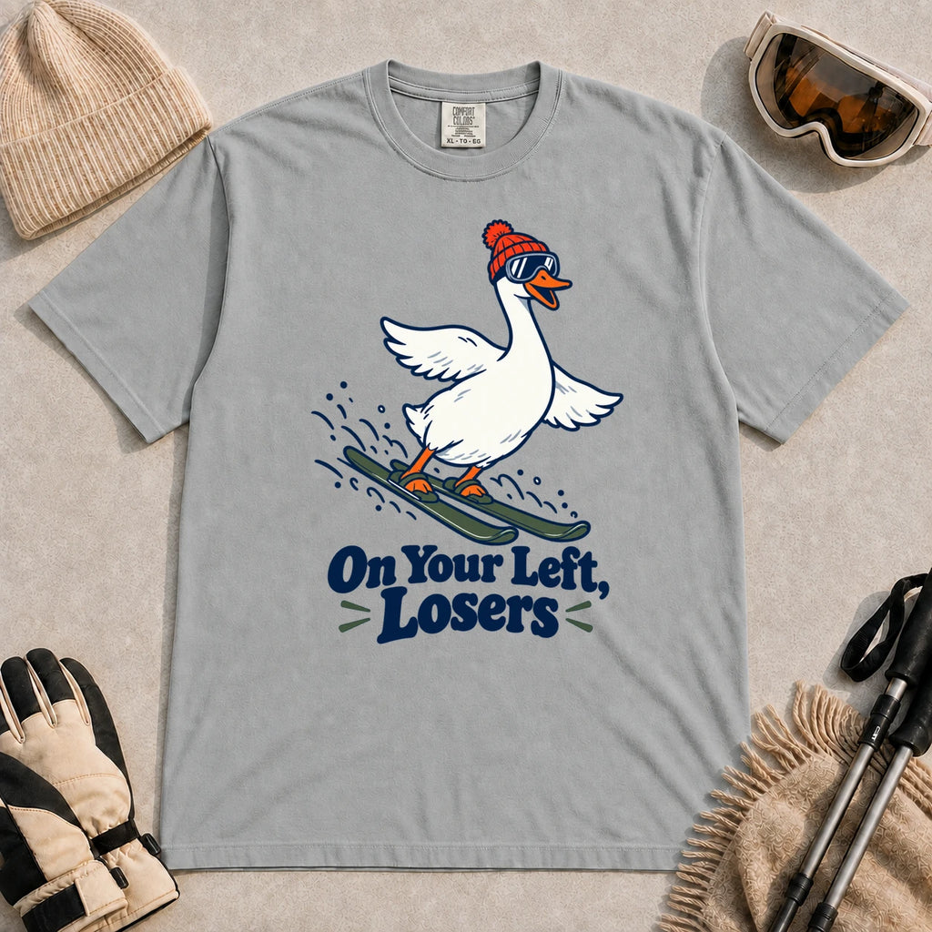 Granite tee featuring a playful goose skiing in goggles and a beanie above the phrase “On Your Left, Losers.”