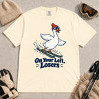 Ivory tee featuring a playful goose skiing in goggles and a beanie above the phrase “On Your Left, Losers.”