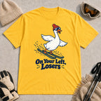 Daisy tee featuring a playful goose skiing in goggles and a beanie above the phrase “On Your Left, Losers.”