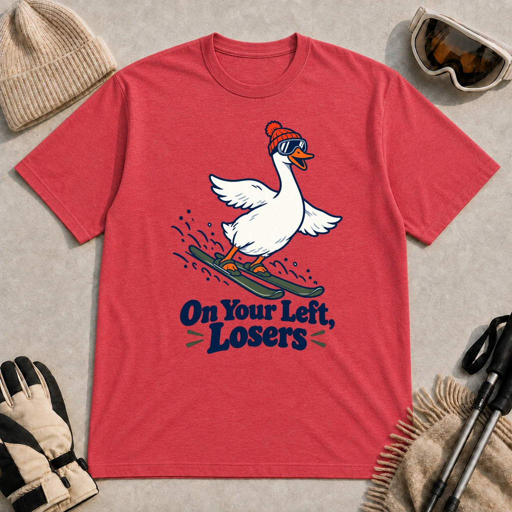 Heather Red tee featuring a playful goose skiing in goggles and a beanie above the phrase “On Your Left, Losers.”