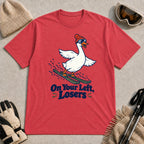 Heather Red tee featuring a playful goose skiing in goggles and a beanie above the phrase “On Your Left, Losers.”