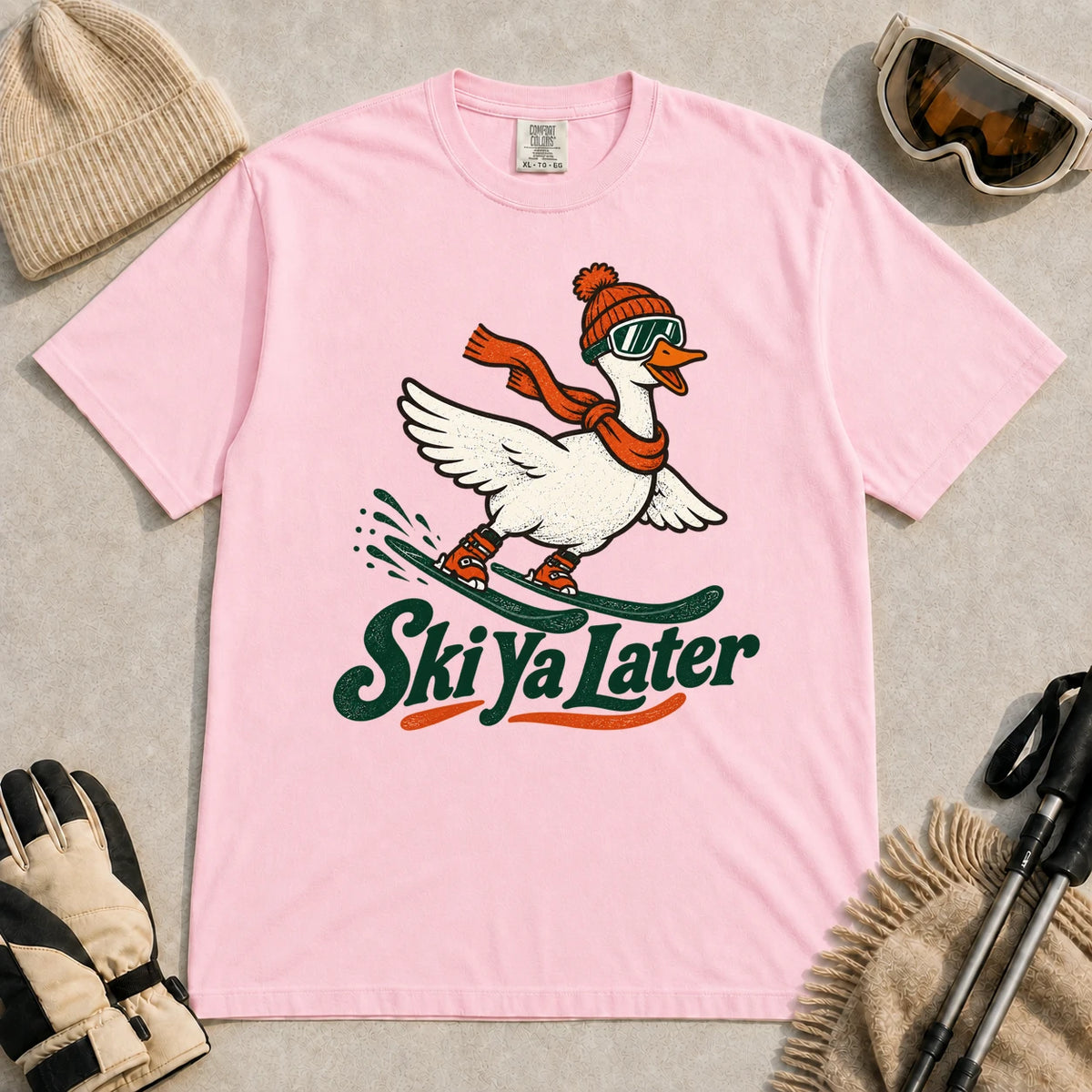 Blossom tee featuring a playful goose skiing in goggles and a beanie above the phrase “On Your Left, Losers.”
