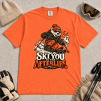 Burnt Orange tee featuring a polar bear skiing through a spooky Halloween scene with a ghost and crescent moon above the phrase “Ski You in the Afterlife.”