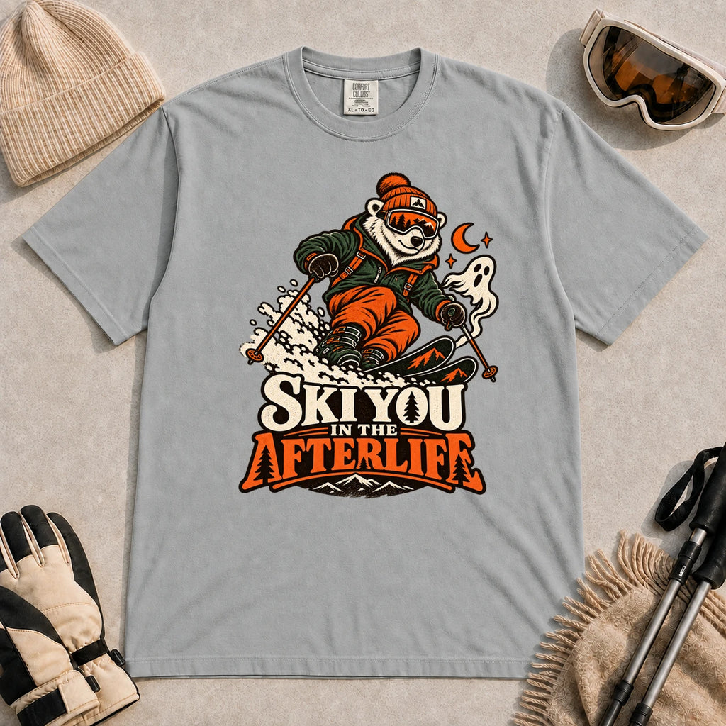 Granite tee featuring a polar bear skiing through a spooky Halloween scene with a ghost and crescent moon above the phrase “Ski You in the Afterlife.”