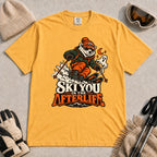 Mustard tee featuring a polar bear skiing through a spooky Halloween scene with a ghost and crescent moon above the phrase “Ski You in the Afterlife.”