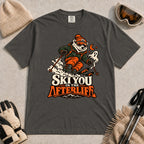 Pepper tee featuring a polar bear skiing through a spooky Halloween scene with a ghost and crescent moon above the phrase “Ski You in the Afterlife.”