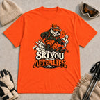 Orange tee featuring a polar bear skiing through a spooky Halloween scene with a ghost and crescent moon above the phrase “Ski You in the Afterlife.”