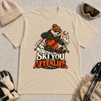 Sand tee featuring a polar bear skiing through a spooky Halloween scene with a ghost and crescent moon above the phrase “Ski You in the Afterlife.”