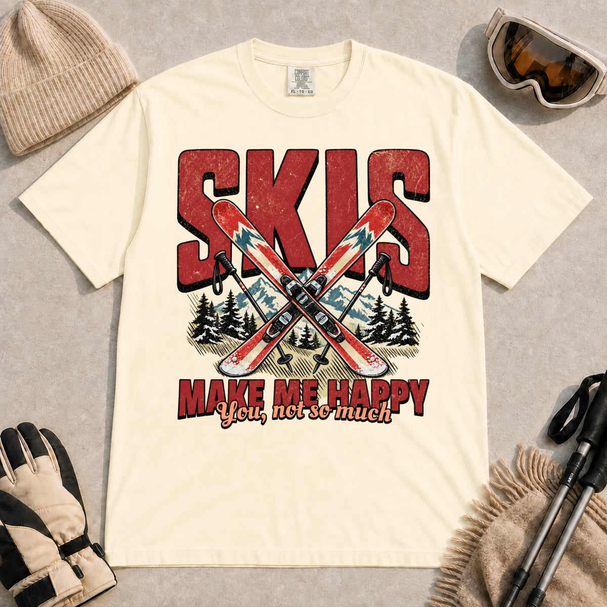 Ivory tee featuring crossed skis and poles in front of bold retro “Skis” lettering with the phrase “Make Me Happy, You Not So Much.”