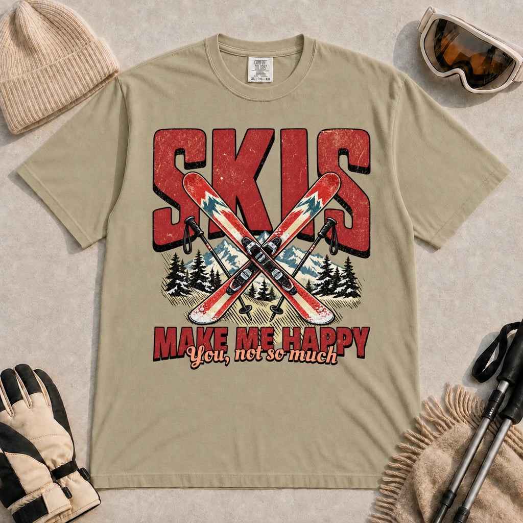 Khaki tee featuring crossed skis and poles in front of bold retro “Skis” lettering with the phrase “Make Me Happy, You Not So Much.”