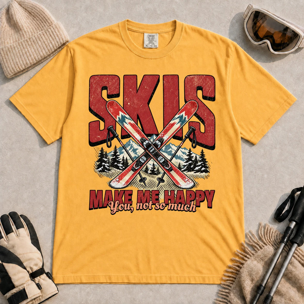 Mustard tee featuring crossed skis and poles in front of bold retro “Skis” lettering with the phrase “Make Me Happy, You Not So Much.”