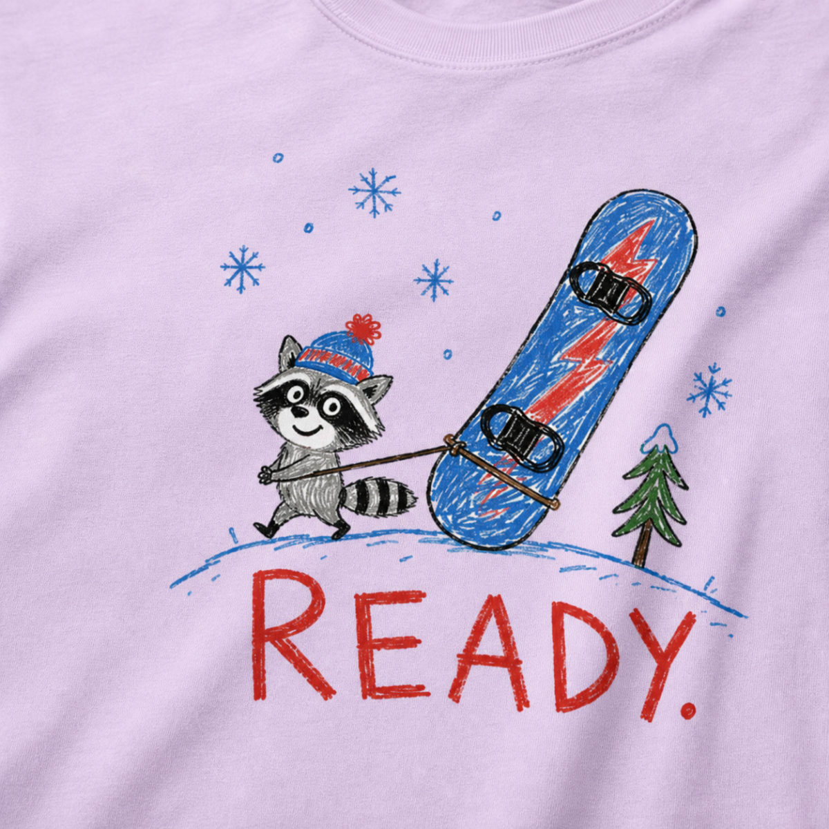 Close-up of an orchid t-shirt with a playful hand-drawn raccoon snowboarding graphic, snowflakes, a pine tree, and large red “READY.” text.
