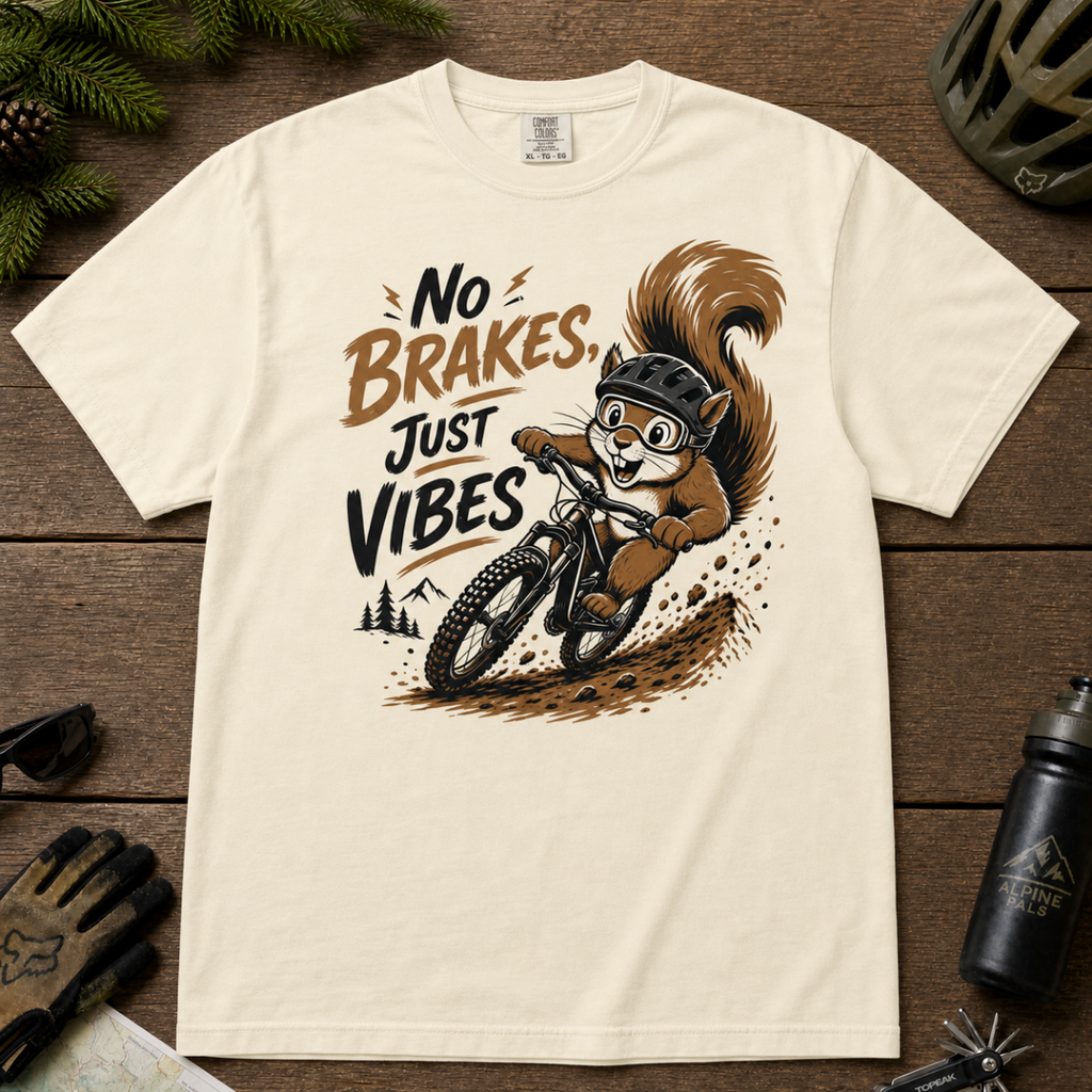 Ivory white t-shirt featuring a squirrel mountain biking down a dirt trail with bold “No Brakes, Just Vibes” lettering.