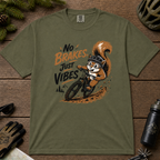 Hemp green t-shirt featuring a squirrel mountain biking down a dirt trail with bold “No Brakes, Just Vibes” lettering.