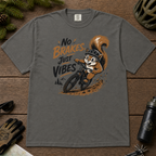 Pepper gray t-shirt featuring a squirrel mountain biking down a dirt trail with bold “No Brakes, Just Vibes” lettering.