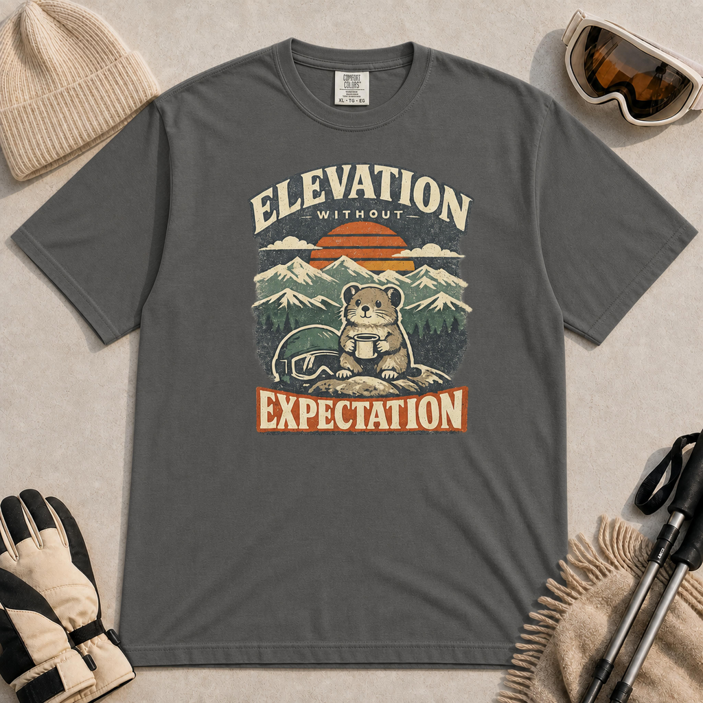 Pepper tee featuring a small mountain rodent holding a mug beside ski goggles, with a retro alpine sunset and “Elevation Without Expectation” text.