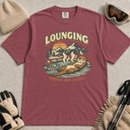 Brick t-shirt featuring a vintage otter lounging in a mountain hot spring beside ski goggles, with the phrase “Lounging Above Sea Level.”