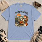Washed denim tee featuring a relaxed fox lounging in a wooden chair with ski goggles and a mug, framed by mountain scenery and the phrase “Good Views, Few Plans.”