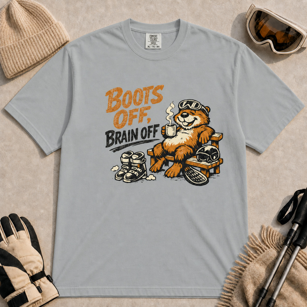 Granite t-shirt featuring a smiling beaver resting after skiing with a hot drink, goggles, ski boots, helmet and snowboard beneath the distressed phrase “Boots Off, Brain Off.”