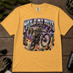 Mustard Comfort Colors tee with a squirrel mountain biking through flying acorns and bold “Hold My Nuts” graphic.