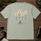 Bay Comfort Colors tee featuring four oversized daisies above a female mountain biker riding alongside a small yellow dog.