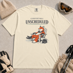 Ivory tee featuring a relaxed fox reclining in an Adirondack chair beside a ski helmet with “Comfortably Unscheduled” text.