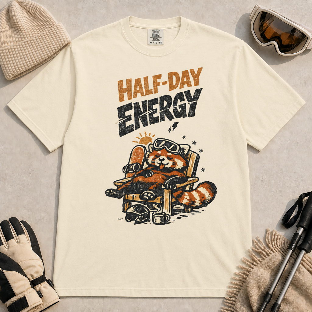 Ivory tee featuring a relaxed red panda lounging in a chair with snowboard gear and the phrase “Half-Day Energy.”