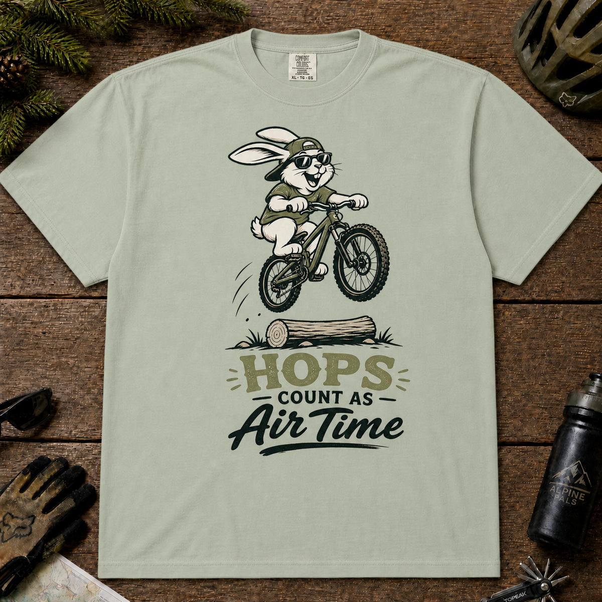 Bay tee featuring a rabbit mountain biking over a log with sunglasses and the phrase “Hops Count as Air Time.”