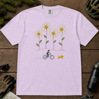 Ivory Comfort Colors tee featuring four oversized daisies above a female mountain biker riding alongside a small yellow dog.