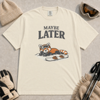 Ivory t-shirt featuring a relaxed red panda lying in the snow beside a snowboard, wearing ski goggles beneath the phrase “Maybe Later.”