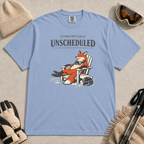 Washed denim blue tee featuring a relaxed fox reclining in an Adirondack chair beside a ski helmet with “Comfortably Unscheduled” text.